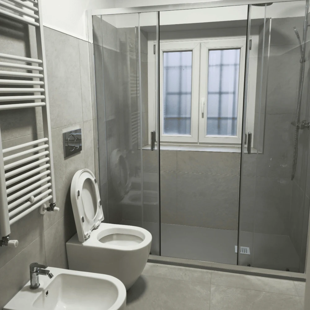 Dettaglio bagno ristrutturato con box doccia e rivestimenti in ceramica ad Alba